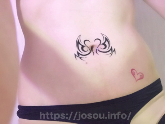 お腹にタトゥーシールを貼っている写真